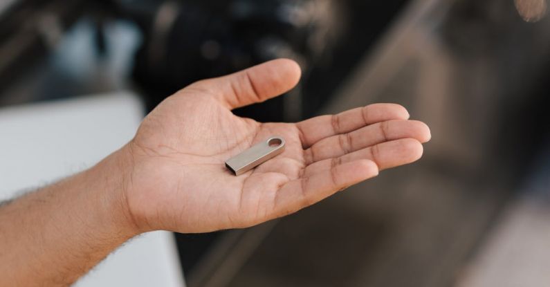 Software Tools - From above of crop anonymous male demonstrating modern portable memory device on palm of hand