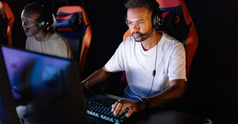 Gaming Tournament - Photo of a Man in a White Shirt Playing on a Computer