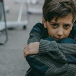 Harassment - A Sad Boy Sitting on a Floor of a Classroom